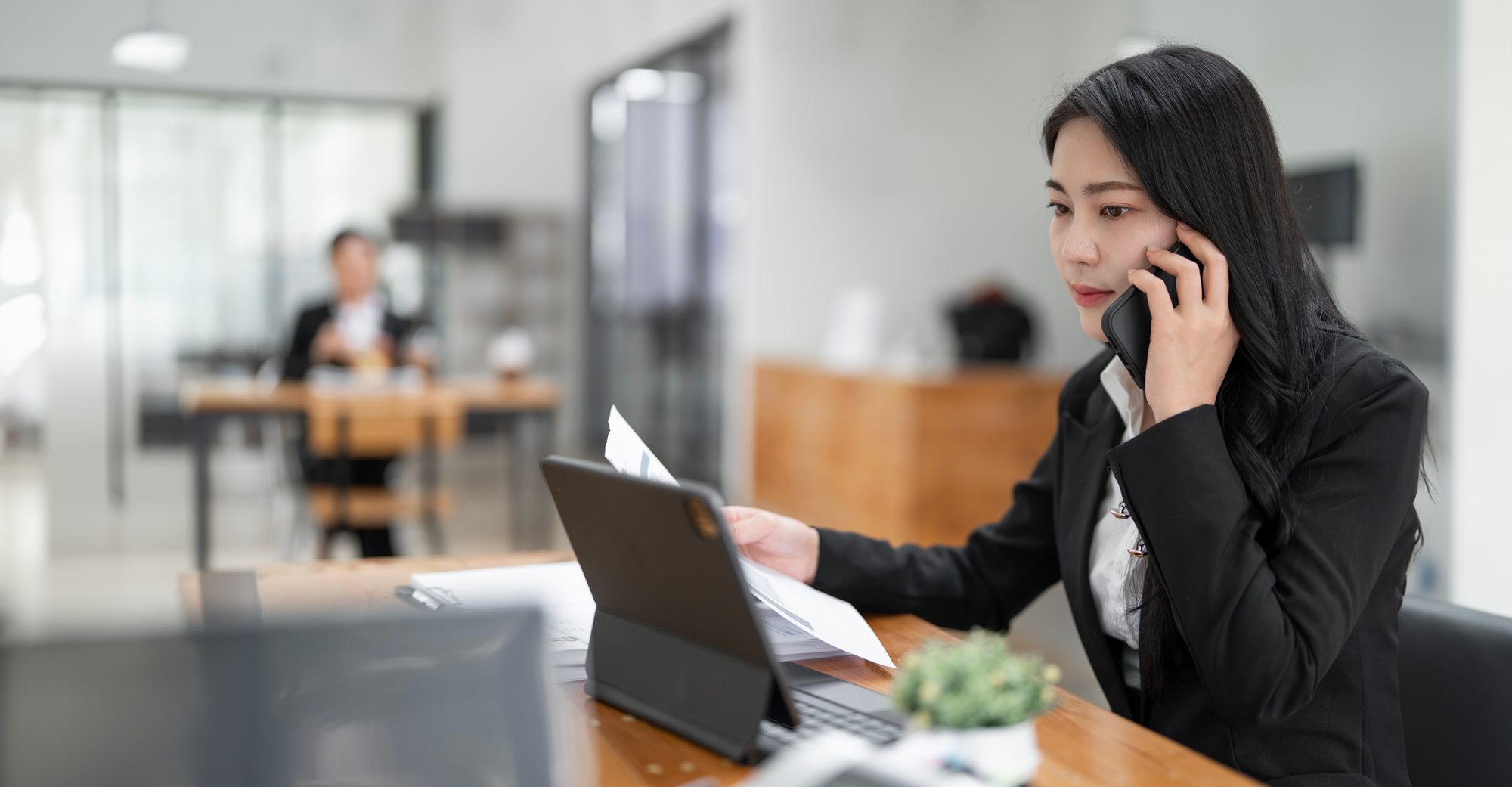 Vertriebsleiterin telefoniert konzentriert im modernen Büro, Sinnbild für die Kompetenzfalle, in der die Chefin jeden Kunden weiter selbst rettet