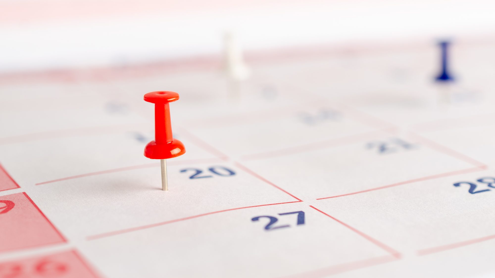 Roter Pin markiert ein Datum im Kalender, Sinnbild für den Verfallstermin, an dem ein Status quo aktiv neu entschieden wird