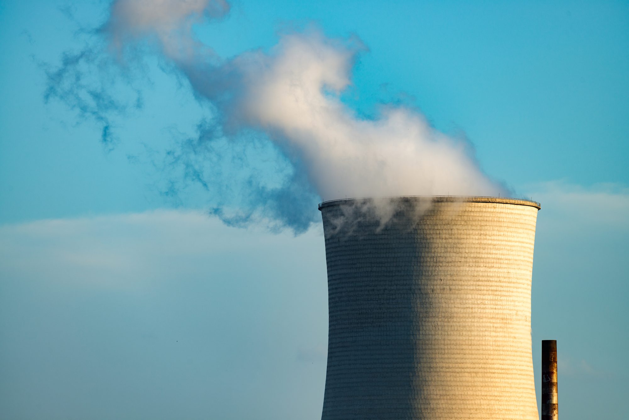 Kühlturm eines Kraftwerks stößt Dampf in den blauen Himmel, Sinnbild für die große Entscheidung, die im Gremium in zweieinhalb Minuten durchgewunken wird