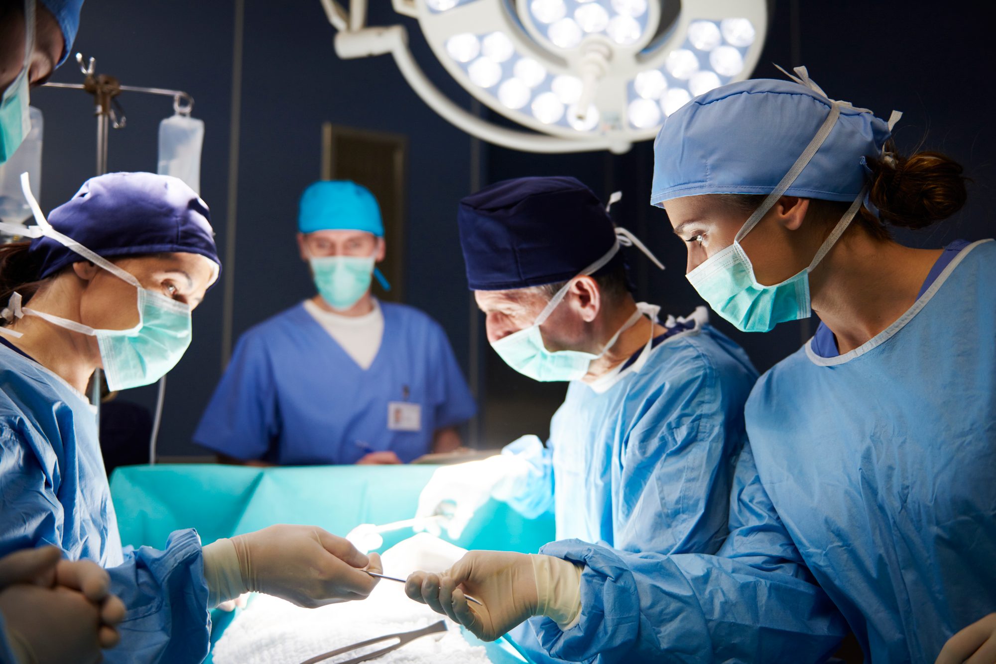 Chirurgisches Team arbeitet konzentriert im Operationssaal, Sinnbild für Brooks' Modell des chirurgischen Teams mit kleiner Kerngruppe und Unterstützern