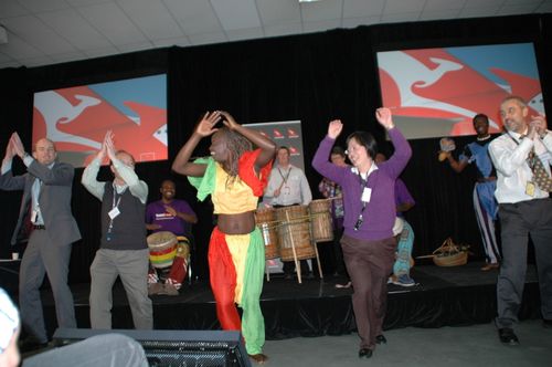 A group of African drummers seated in a semi-circle, each playing hand-carved drums with focused intensity. Their synchronized rhythms create a powerful, communal energy. #AfricanDrumming #CulturalRhythm #LivePercussion #AfricanMusic #TraditionalDrums