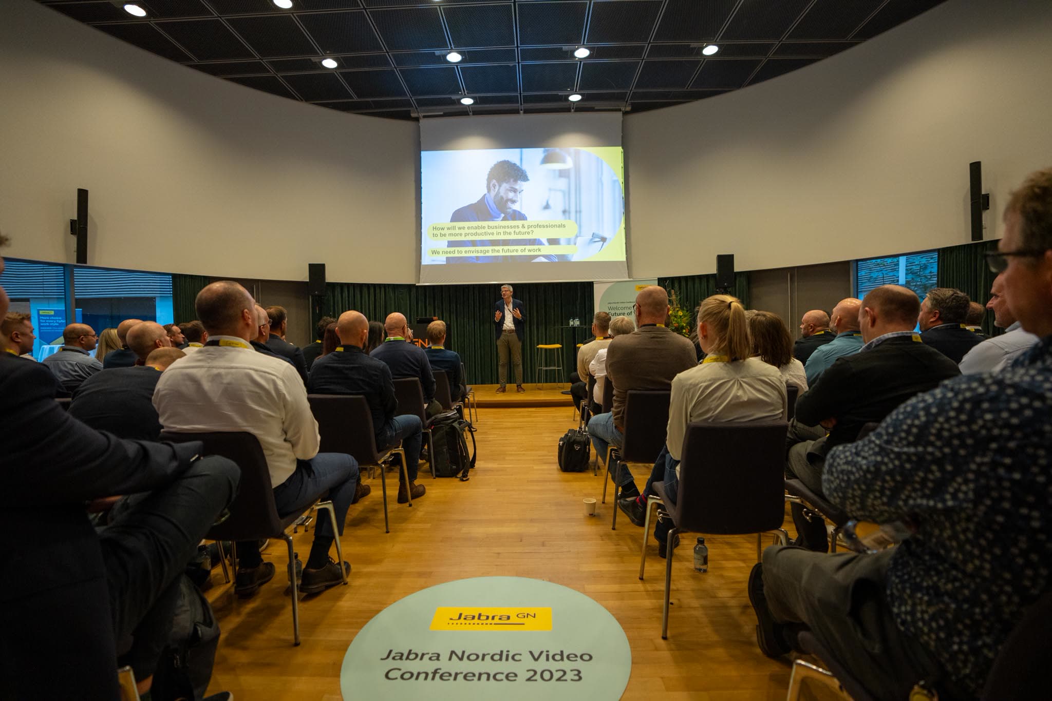 Fyldt konferencesal hos Jabra i Ballerup med gulvdekal fra Jabra Nordic Video Conference 2023