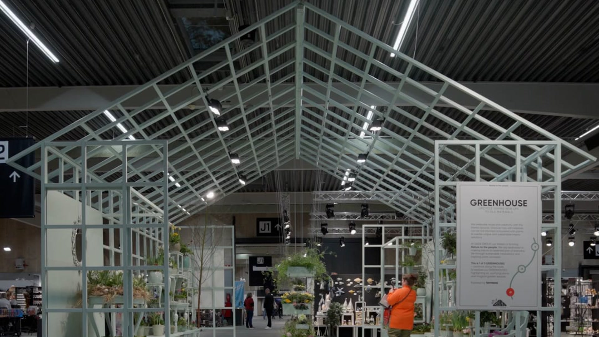 GASA GROUPs Greenhouse-installation på Formland-messen i Herning — hvidt drivhusstel fyldt med planter og en messegæst i orange jakke