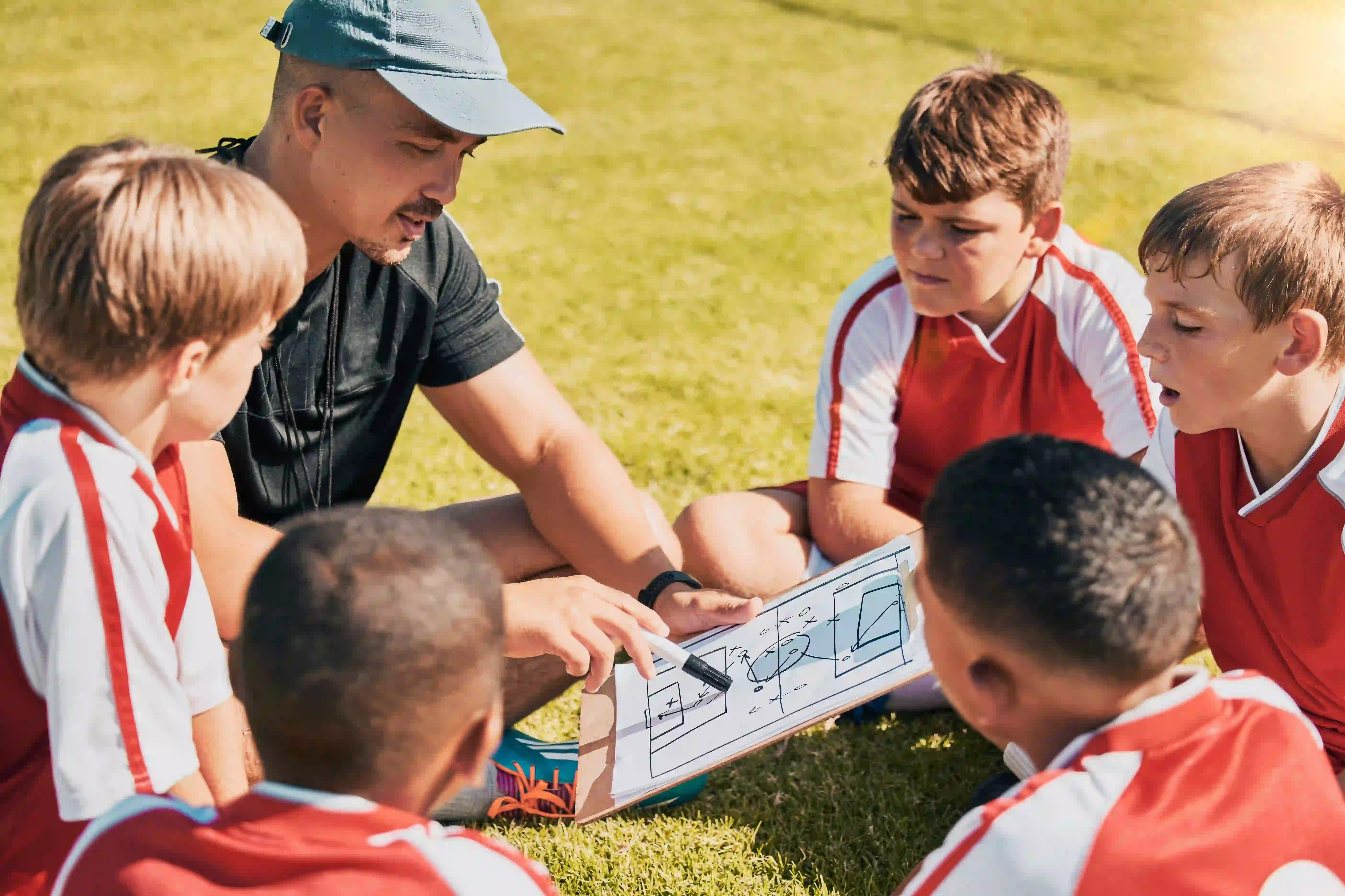 coach with youth soccer athletes in circle