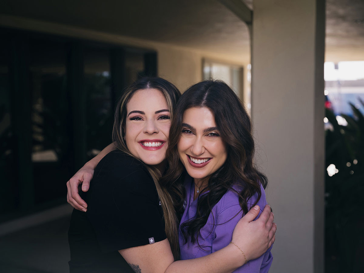 Two smiling Serene Dentistry team members outside the Ventura office