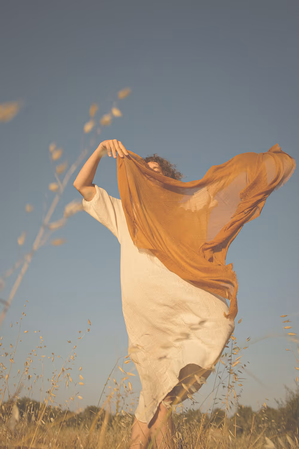A woman in a dress dancing in a field.