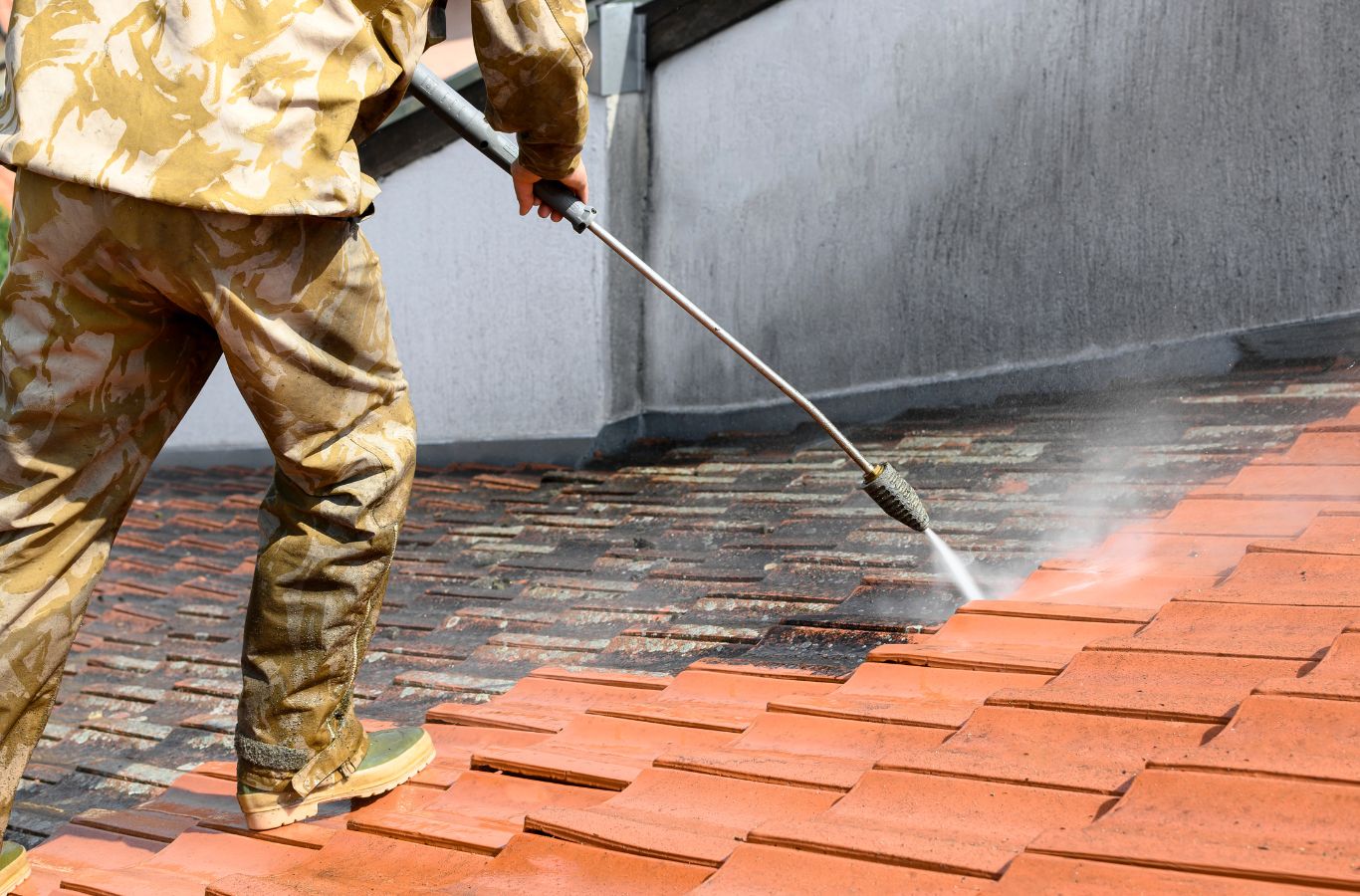 A Marvel Window Washing professional executing roof cleaning in West Los Angeles, CA, illustrating the advantages of local expert care