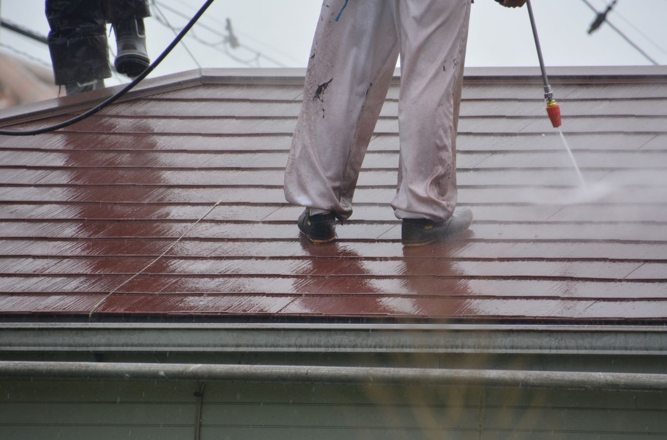 A Marvel Window Washing team member performing roof cleaning in Santa Monica, CA, illustrating the importance of skilled local roof care.