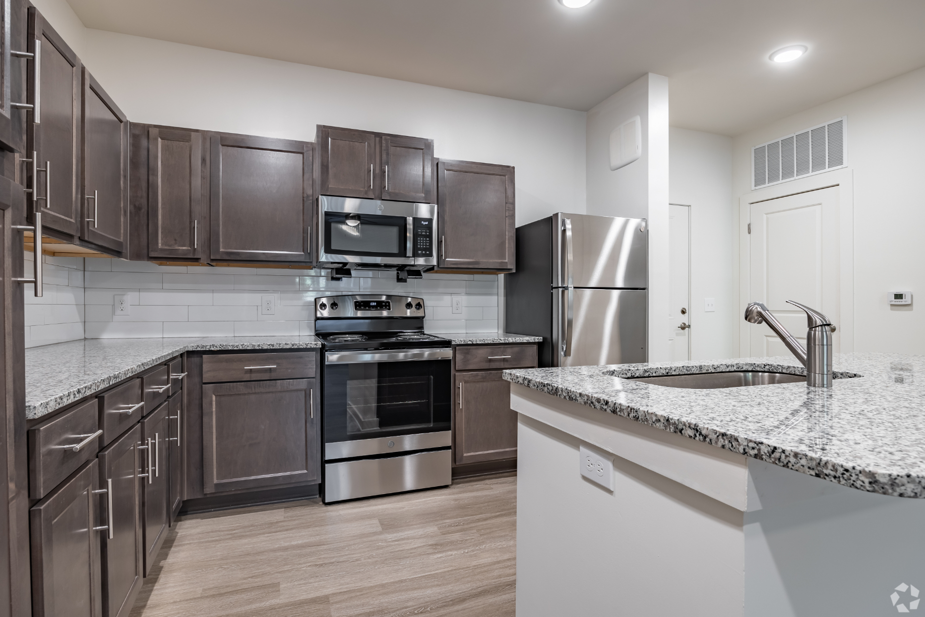 Kitchen with brown cabinets, island, and stainless steel appliances
