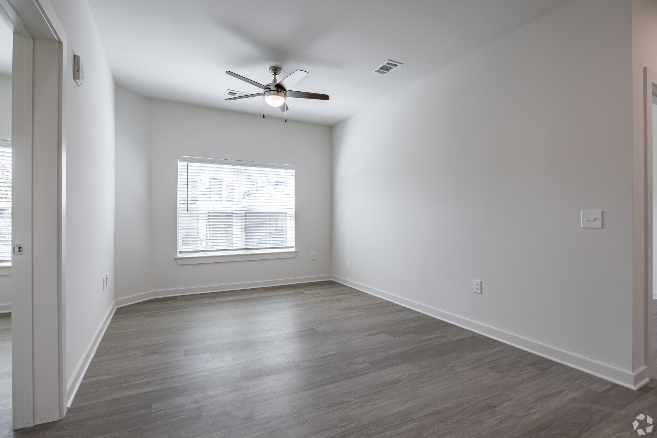 unfurnished living area with ceiling fan and large window