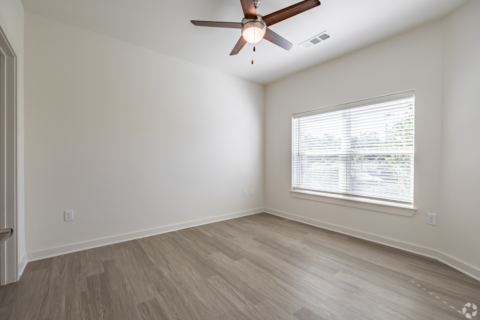unfurnished living area with ceiling fan and large window