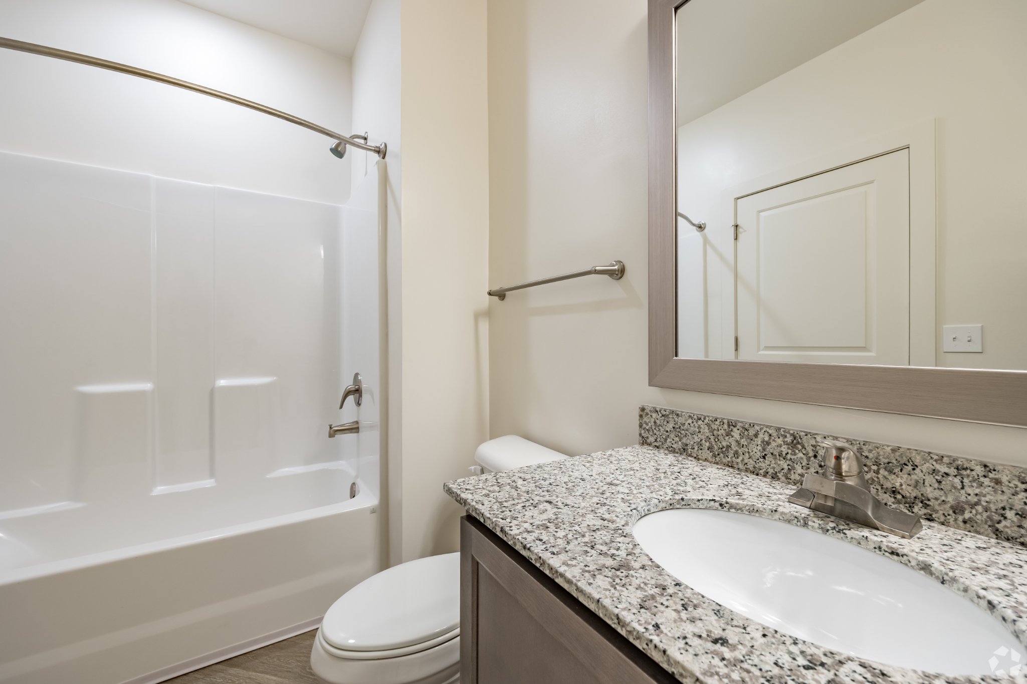 Bathroom with brown cabinets and show tub combo
