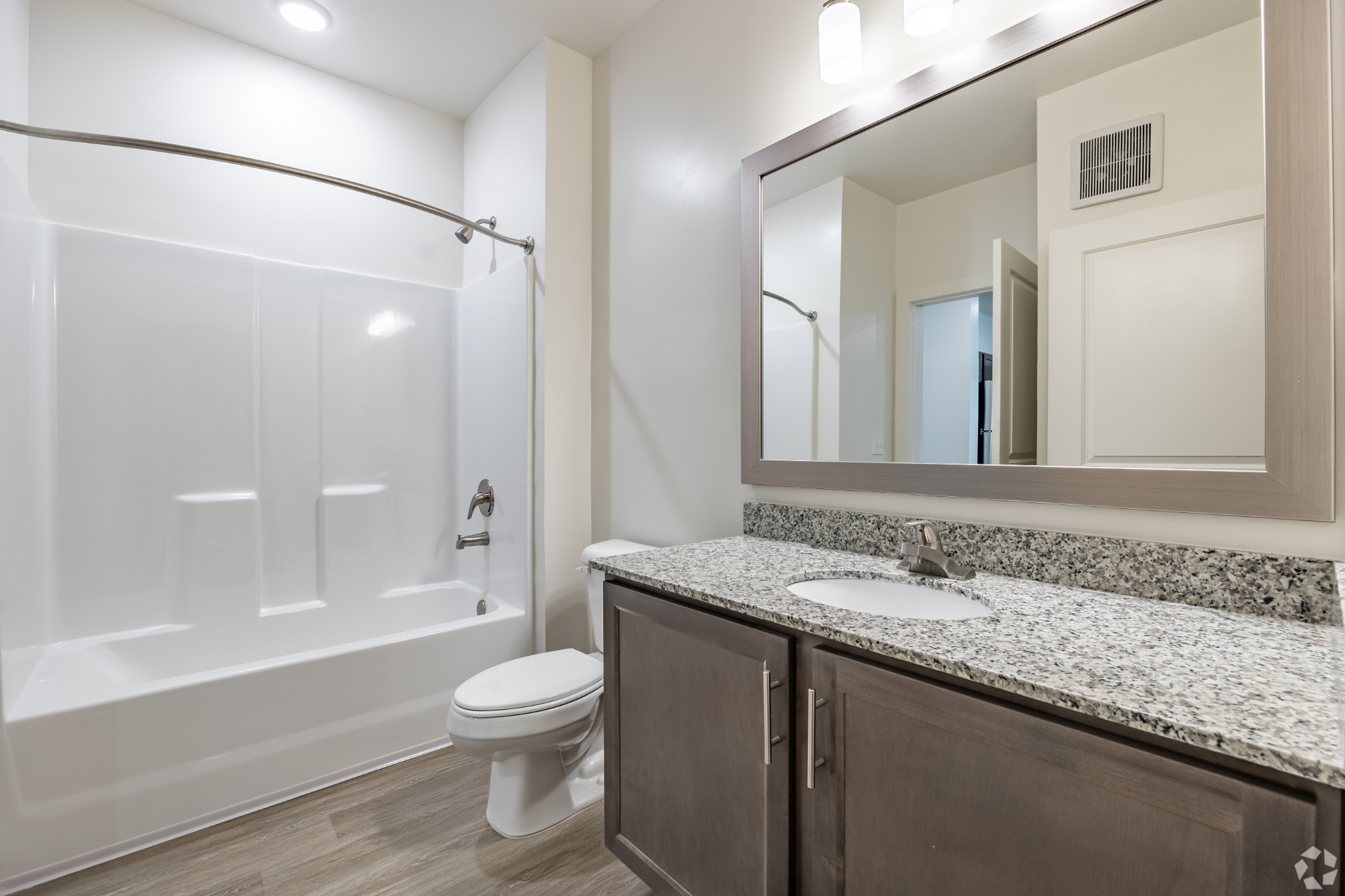 Bathroom with brown cabinets and show tub combo