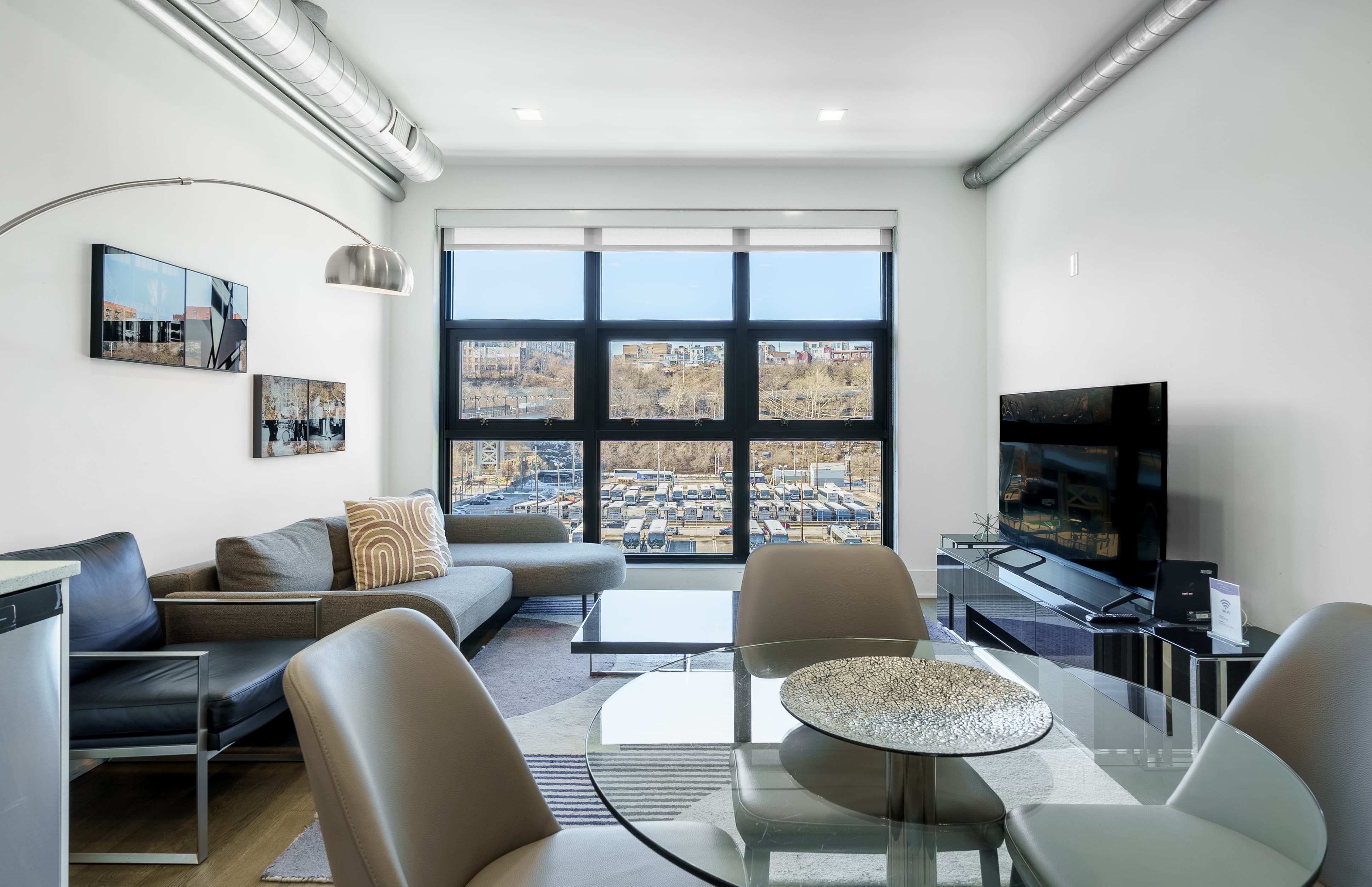 Living and dining area with city view, One Bedroom corporate housing unit, Novia Hoboken