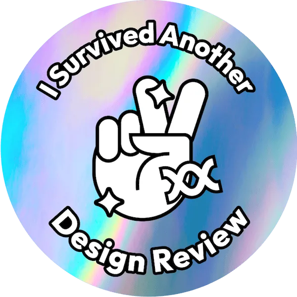 A circular sticker with the words i survived another design review.