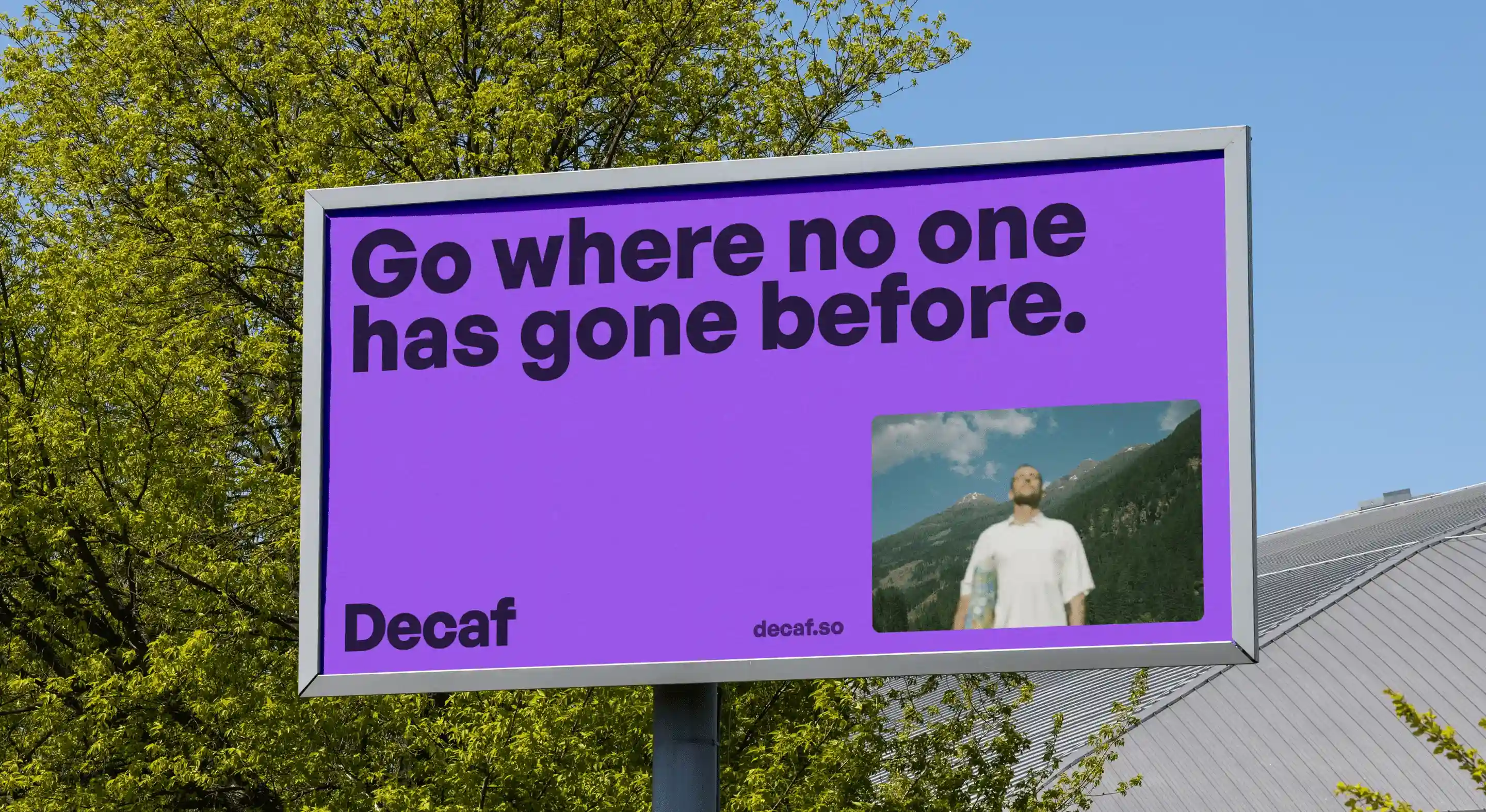 Billboard with purple background displaying the text 'Go where no one has gone before,' a small image of a man with mountains in the background, and the word 'Decaf' with the website decaf.so designed by flexxi