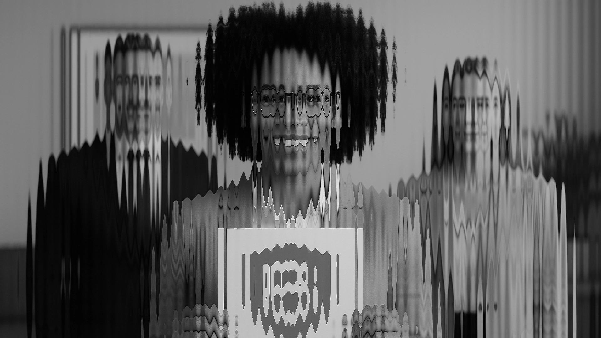 A blurred image of three business people smiling and the middle person holds a sign