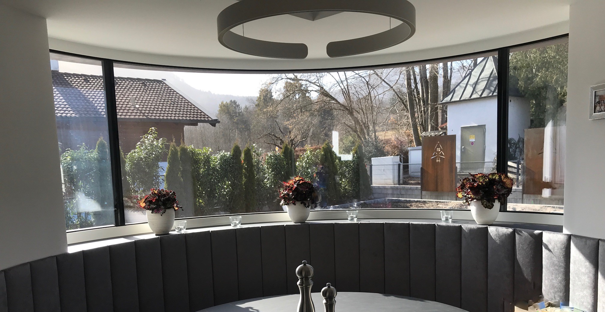 Wohnraum mit großflächigen Aluminiumfenstern und Blick ins Freie