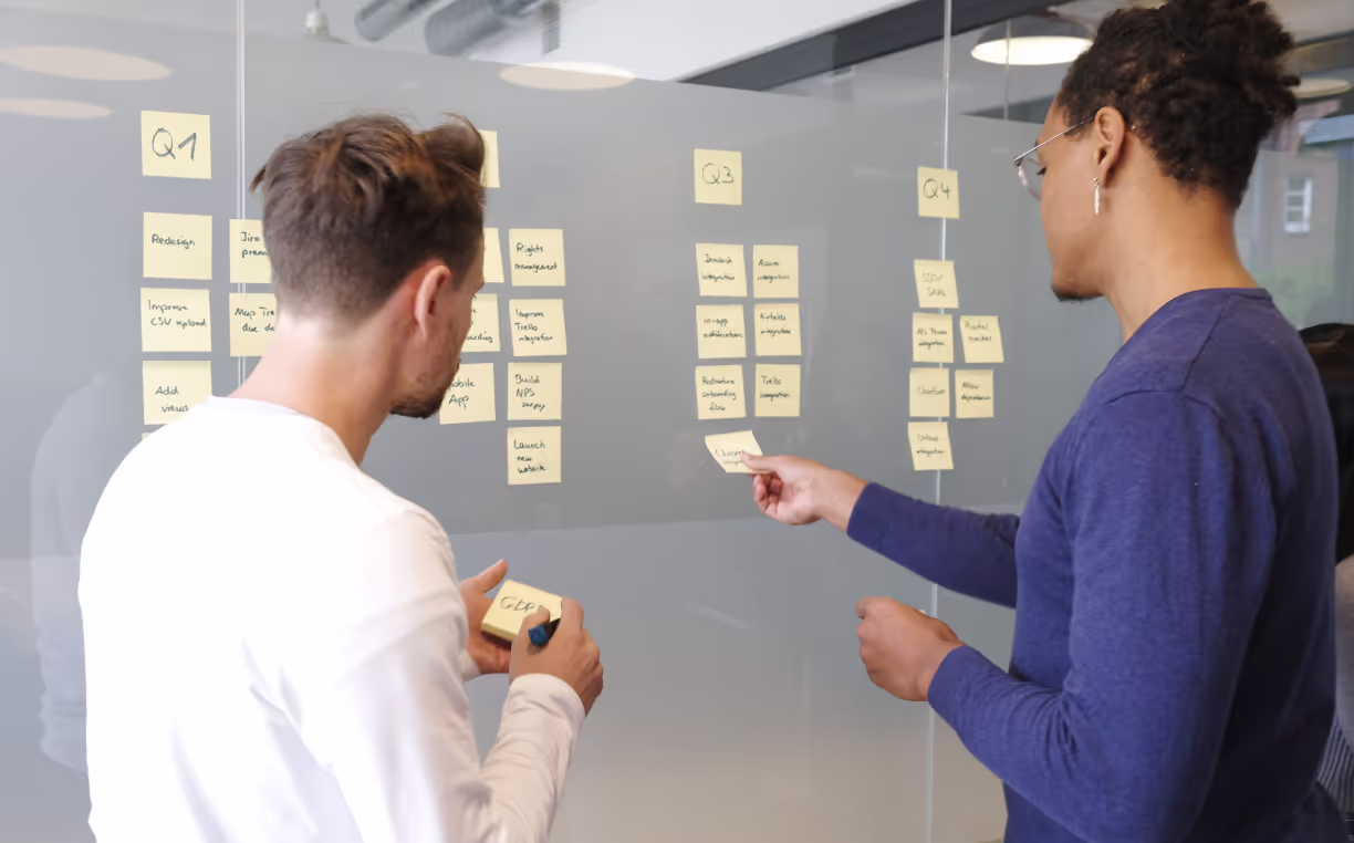 Two people putting small stickers to the wall
