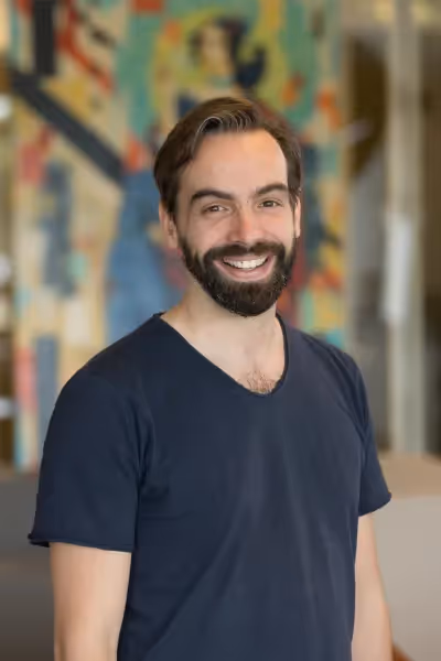 Jasper Bekkers standing in front of a colorful wall, smilling
