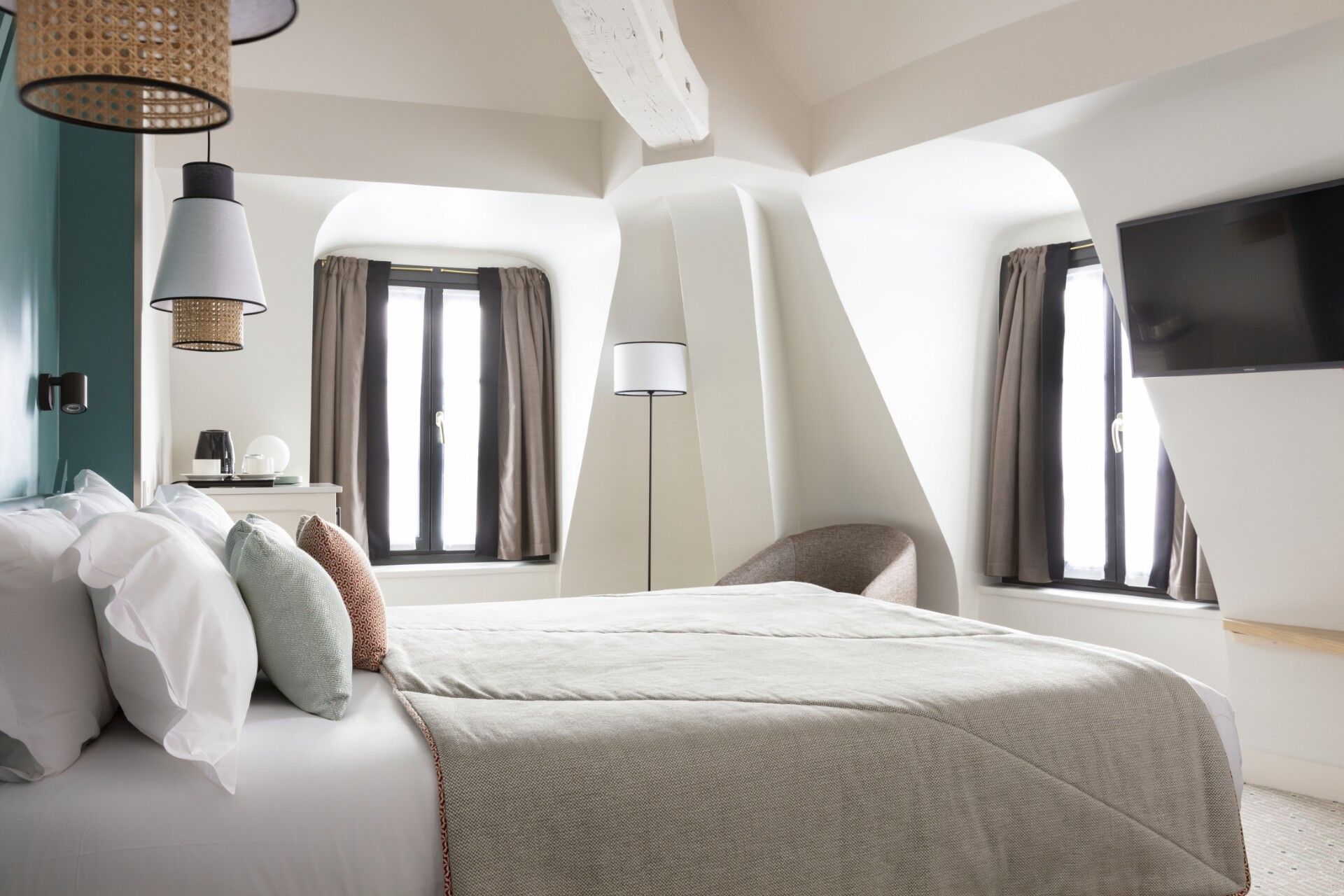 Chambre Deluxe de l’Hôtel Bastille Spéria avec lit double, décoration contemporaine et grandes fenêtres