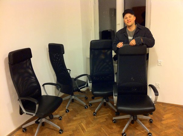 Stano stands behind the chairs in a room
