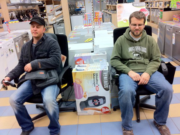 Stano and Weston sitting on a massage chair