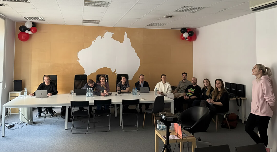A team of people sitting behind the tables watching the AI agents lecture