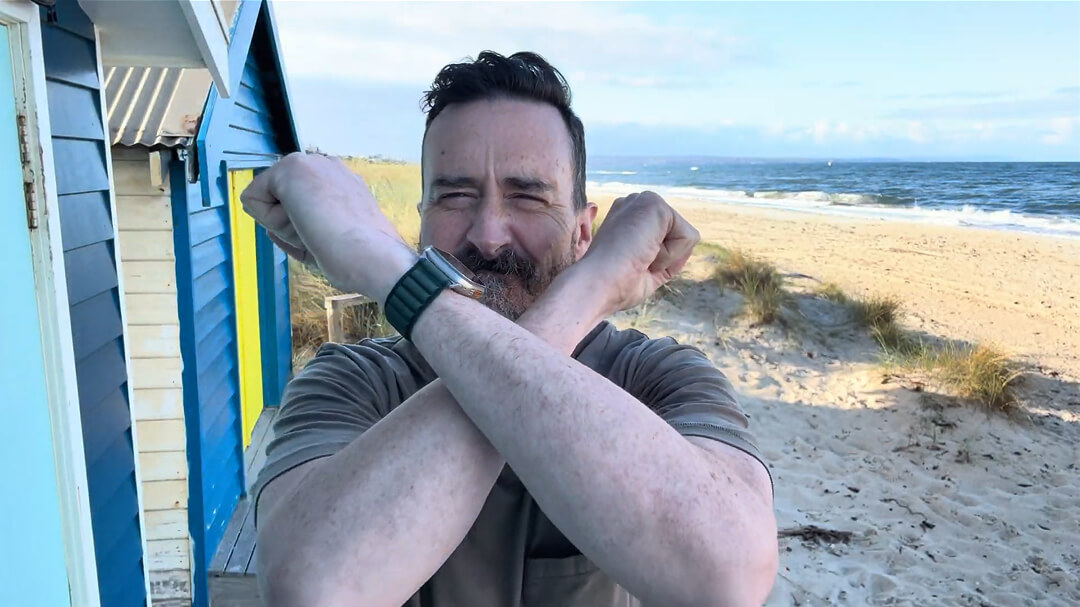 A man showing X with crossed arms on the beach