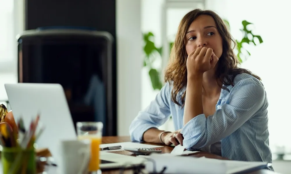 Une personne se questionne devant son bureau
