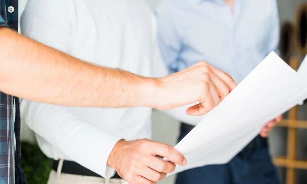 Une personne tient un papier et la seconde pointe du doigt ce papier