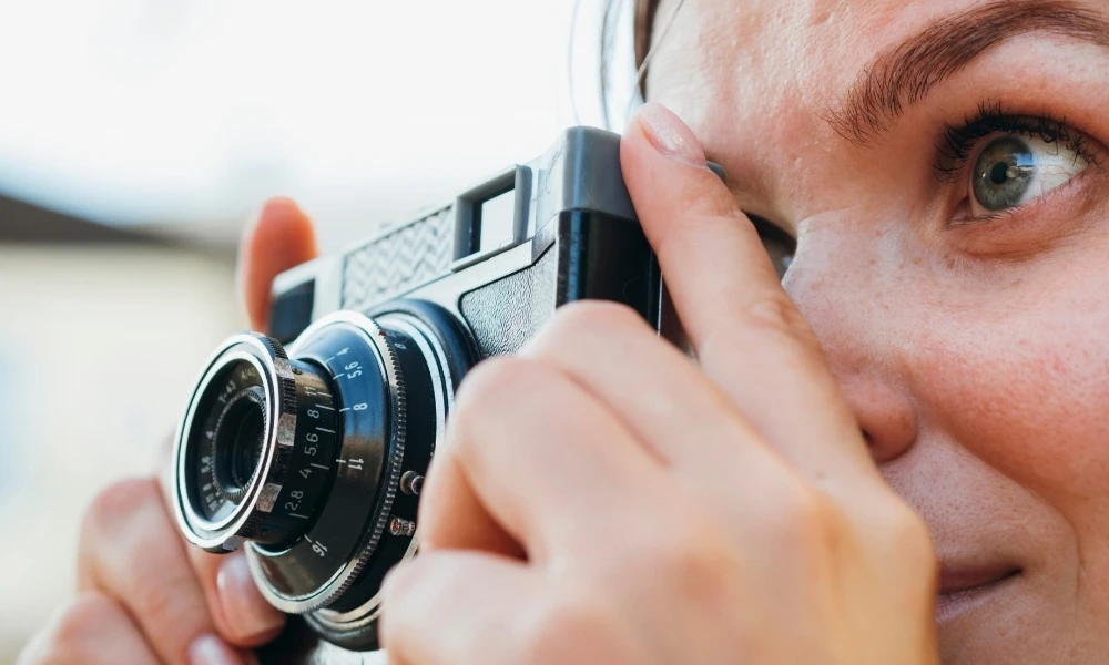 Une personne cadre une photo avec un appareil photo, concentrée sur sa prise de vue.