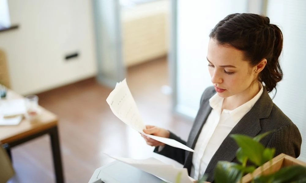 Femme RH en ESSMS consultant des documents dans un bureau lumineux.