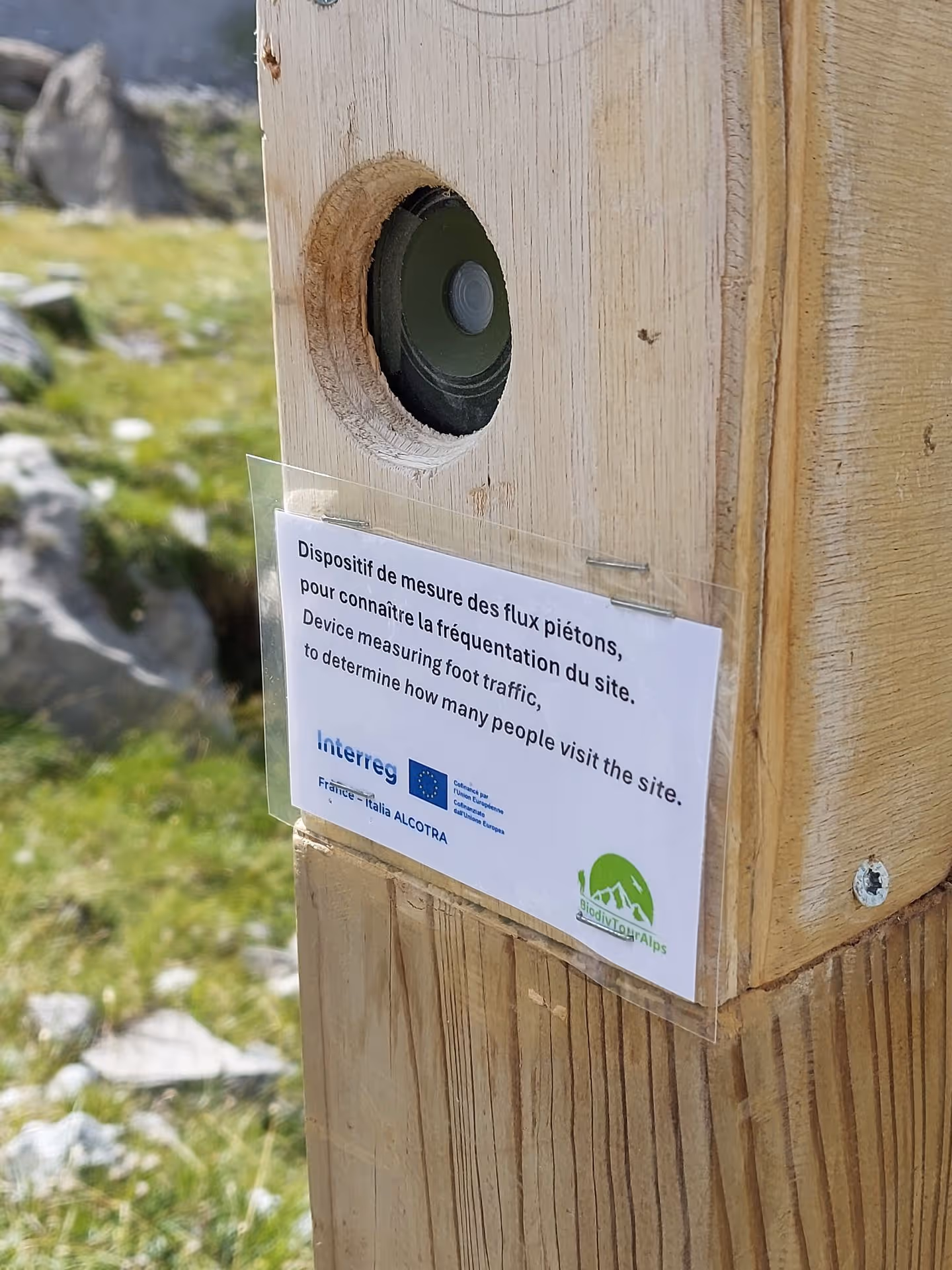 compteur de passage caché dans un poteau de bois sur en sentier de randonnée