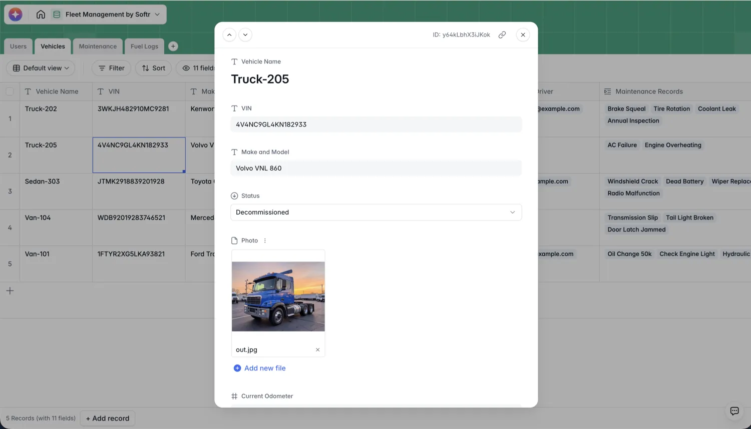 A Vehicles record open in a detail modal in Softr Databases, showing Truck-205, its VIN, a Volvo VNL 860 make and model, a Decommissioned status, and a truck photo