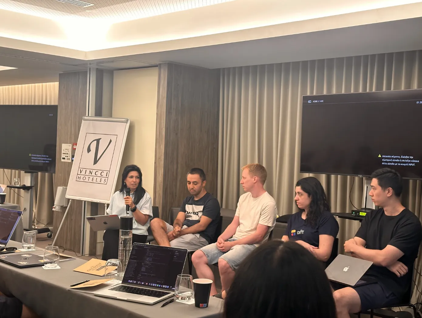Five Softr leaders seated on a panel with a microphone during a fireside session