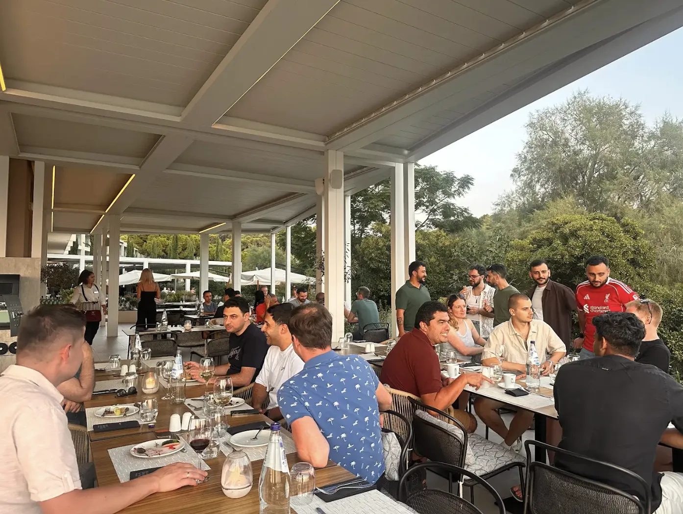 Softr team members seated at a long outdoor dinner table under a covered terrace