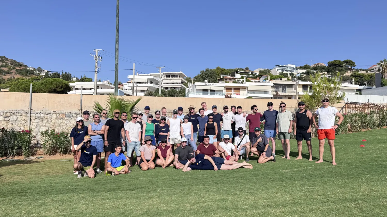 The Softr team posing together on a grass lawn after outdoor team-building games