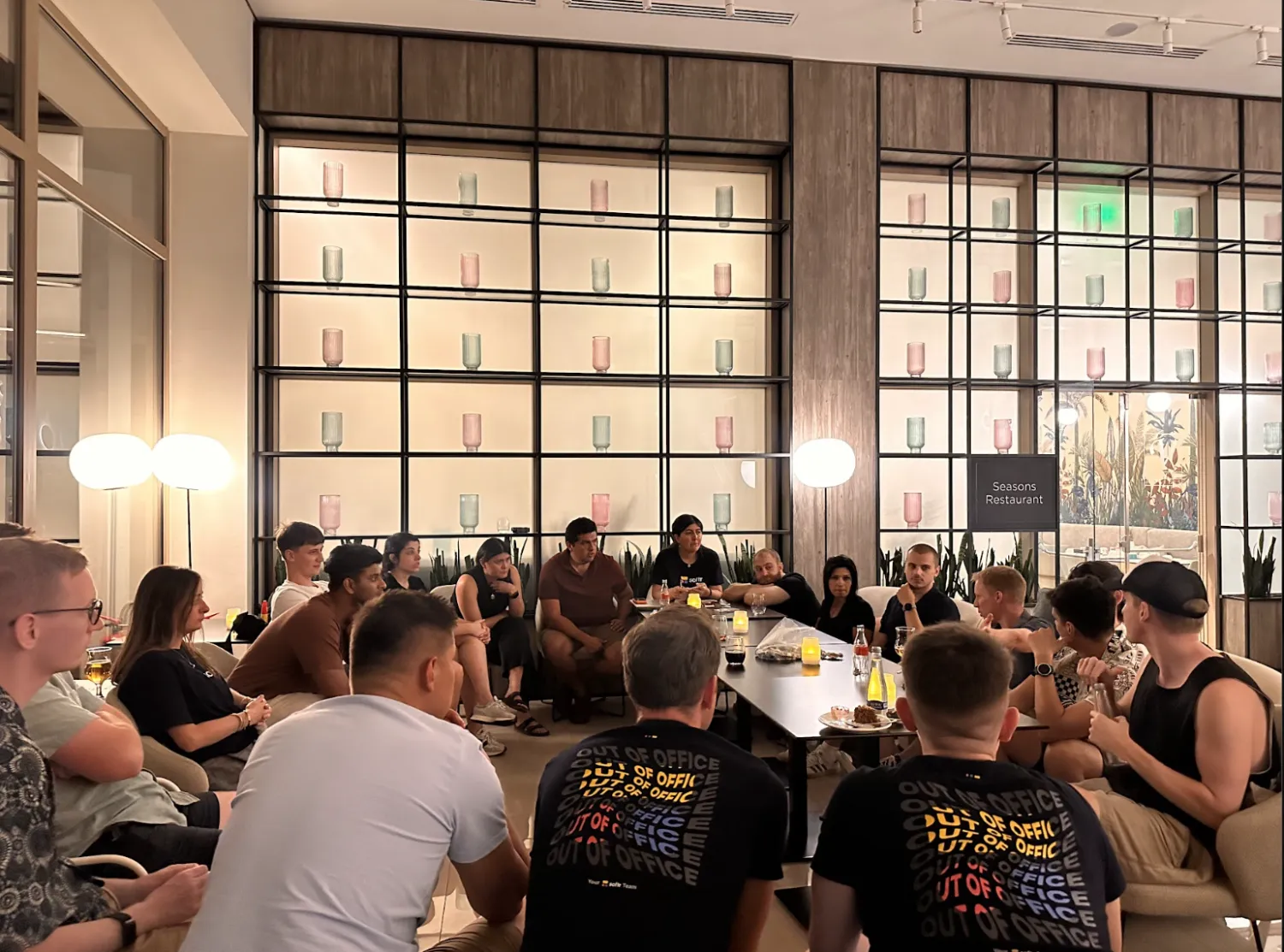 Softr team members sitting in a hotel lounge playing a large group game of Mafia