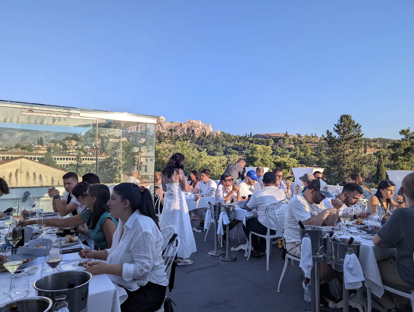 Softr team at a rooftop dinner table with the Acropolis lit by evening sun behind them