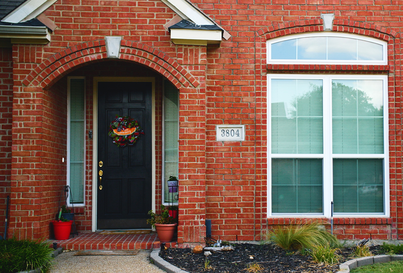 A brick house with a new replacement door from The Window Source of Nashville