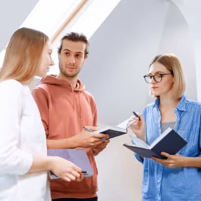 Three people chatting in a relaxed corporate setting