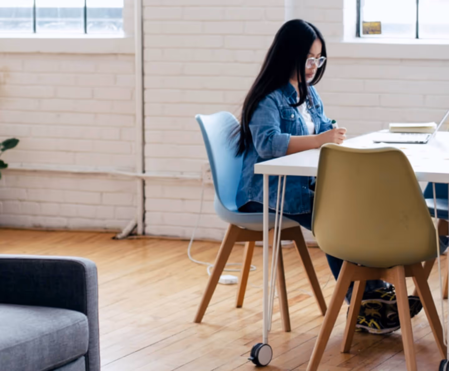 Young lady sat at a desk making notes during a meeting