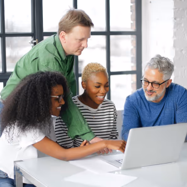 Group of 4 people looking at a laptop