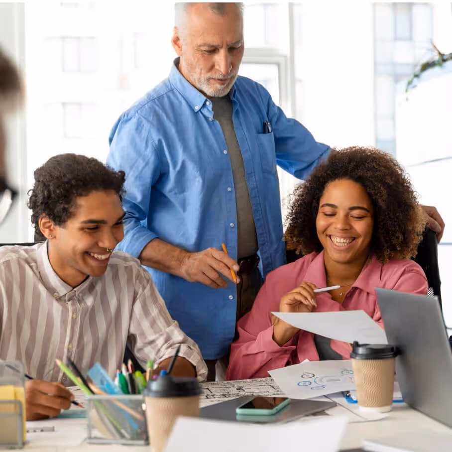 Three people in an office setting viewing and discussing paperwork
