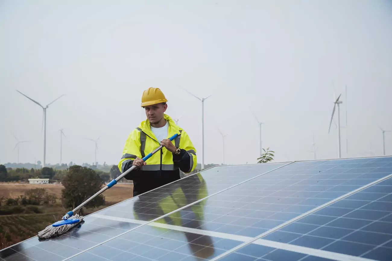 Engineer cleaning a solar panel as part of solar panel maintenance. 