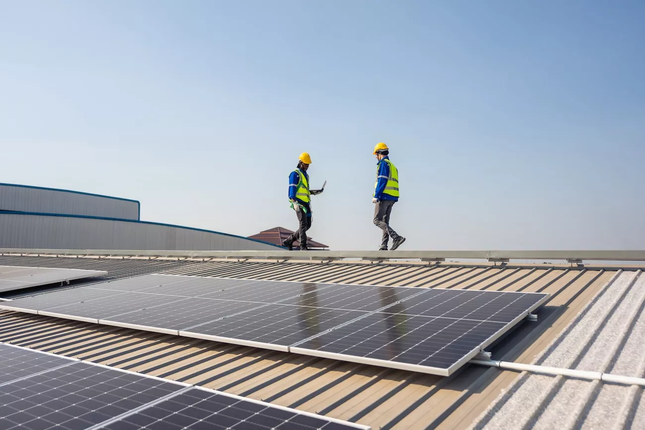 Renewable energy engineer approving solar panel installation. 