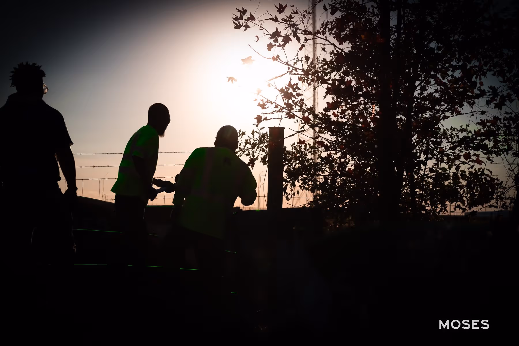 Three silhouetted workers collaborate at sunset on Old Cuyler Rd in Bryan County, GA, demonstrating Moses Grass Company's commitment to transparency and community engagement in their erosion control efforts.