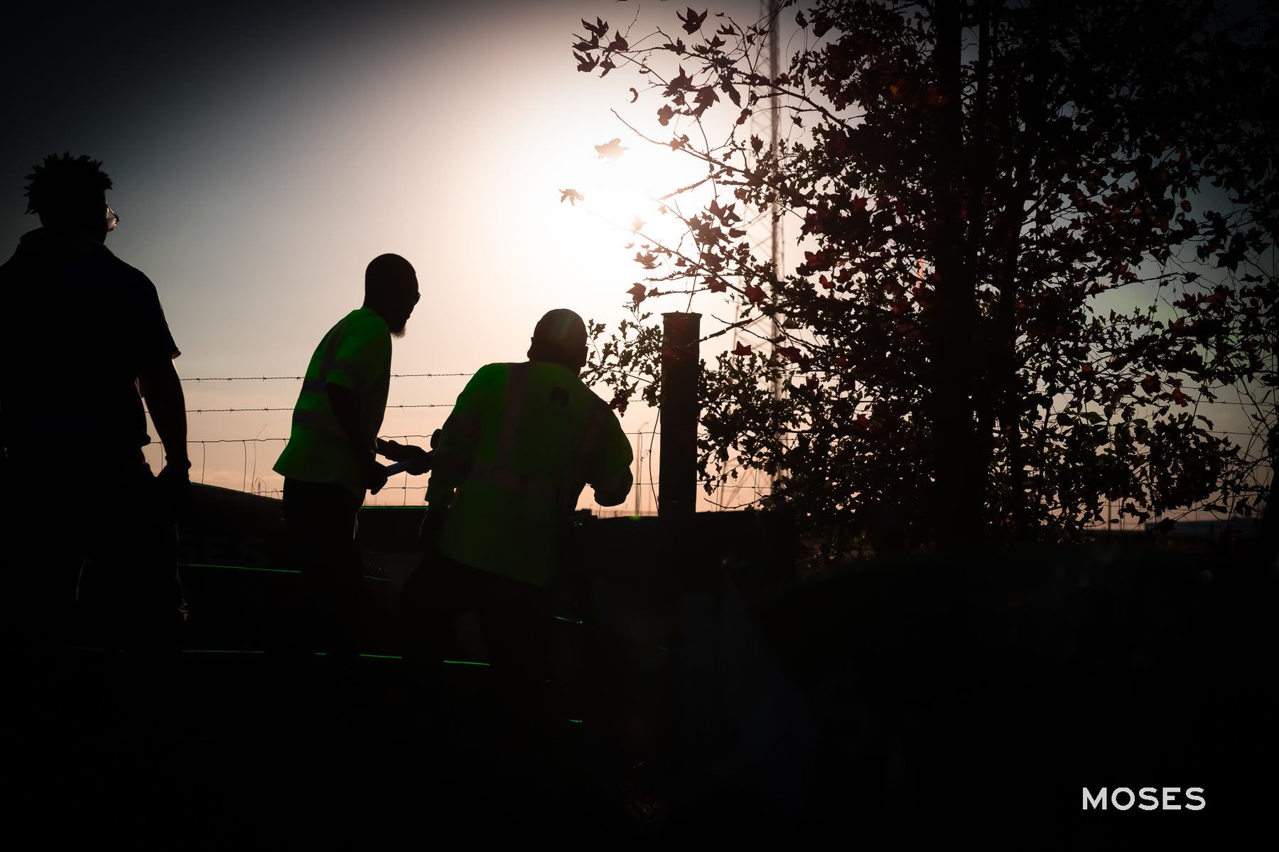 Three silhouetted workers collaborate at sunset on Old Cuyler Rd in Bryan County, GA, demonstrating Moses Grass Company's commitment to transparency and community engagement in their erosion control efforts.