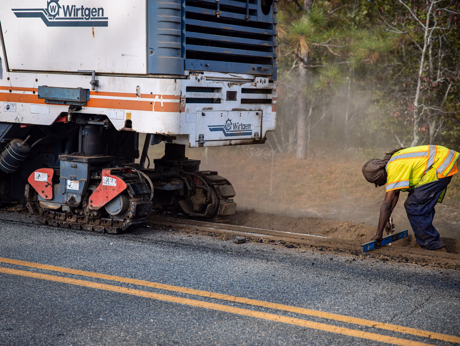 A crew member carefully levels the ground as a Wirtgen milling machine prepares for roadway widening on Cedar Crossing Rd in Vidalia, GA. This project focuses on improving safety and infrastructure through precise striping and signage in...